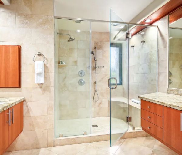 This is a modern bathroom with a large glass shower, double sinks, mirrored walls, and wooden cabinetry on both sides, all neatly arranged.