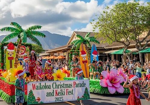 A festive parade on a sunny street with a colorful float reading “Waikoloa Christmas Parade and Ukulele Fest 2025,” tropical decor, performers, and spectators.